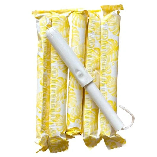 Pack of tampons in yellow packaging with one open tampon lying on top.