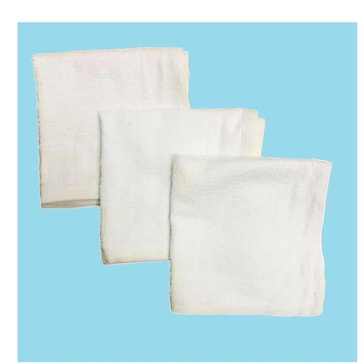 Three folded white cotton washcloths on a blue background.