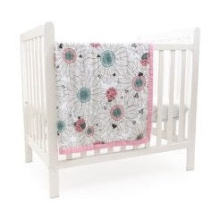 Here are some descriptive alt tags for the image:
* White baby crib with a floral and ladybug patterned quilt.
* Child's crib with a daisy and insect patterned blanket draped over the side.
* Nursery furnishing: white crib with pink-trimmed quilt.
