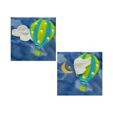 Close-up of blue fabric with embroidered hot air balloon, cloud, moon, and stars.
