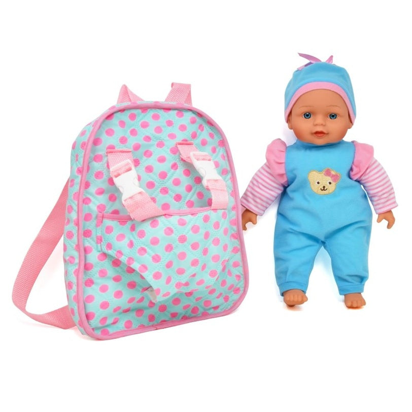 A baby doll in a blue outfit next to a polka dot backpack.