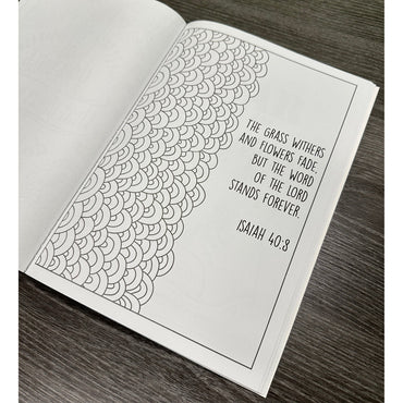 Open book with a black-and-white design featuring a bible verse and decorative art.