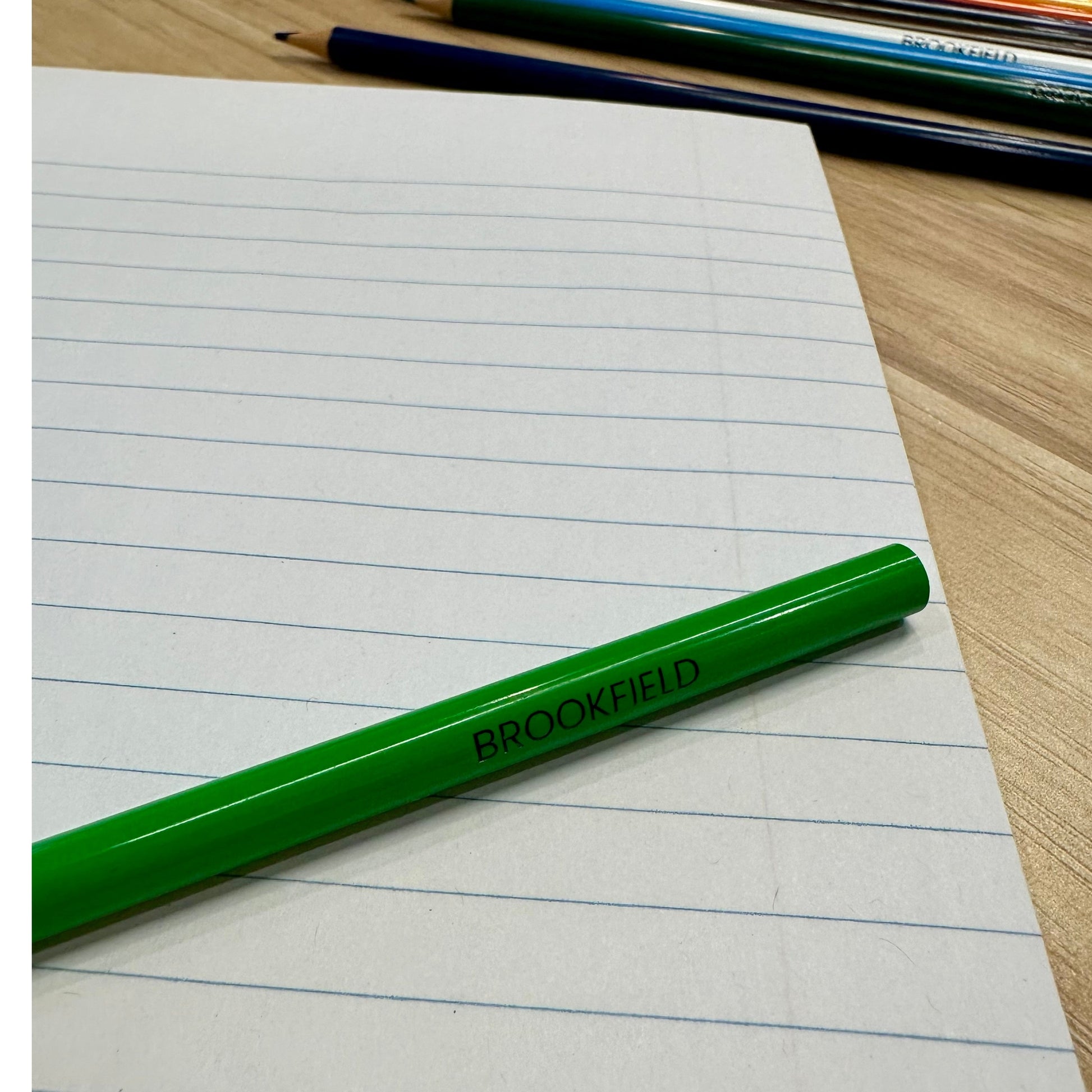 Lined paper with green "Brookfield" pencil and other colored pencils.
