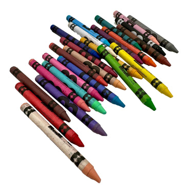 An overhead shot of a variety of crayons in different colors on a white background.