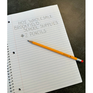 A yellow pencil lies on a notebook with handwritten text that says HDI Wholesale, Brookfield, School Supplies, and #2 Pencils.