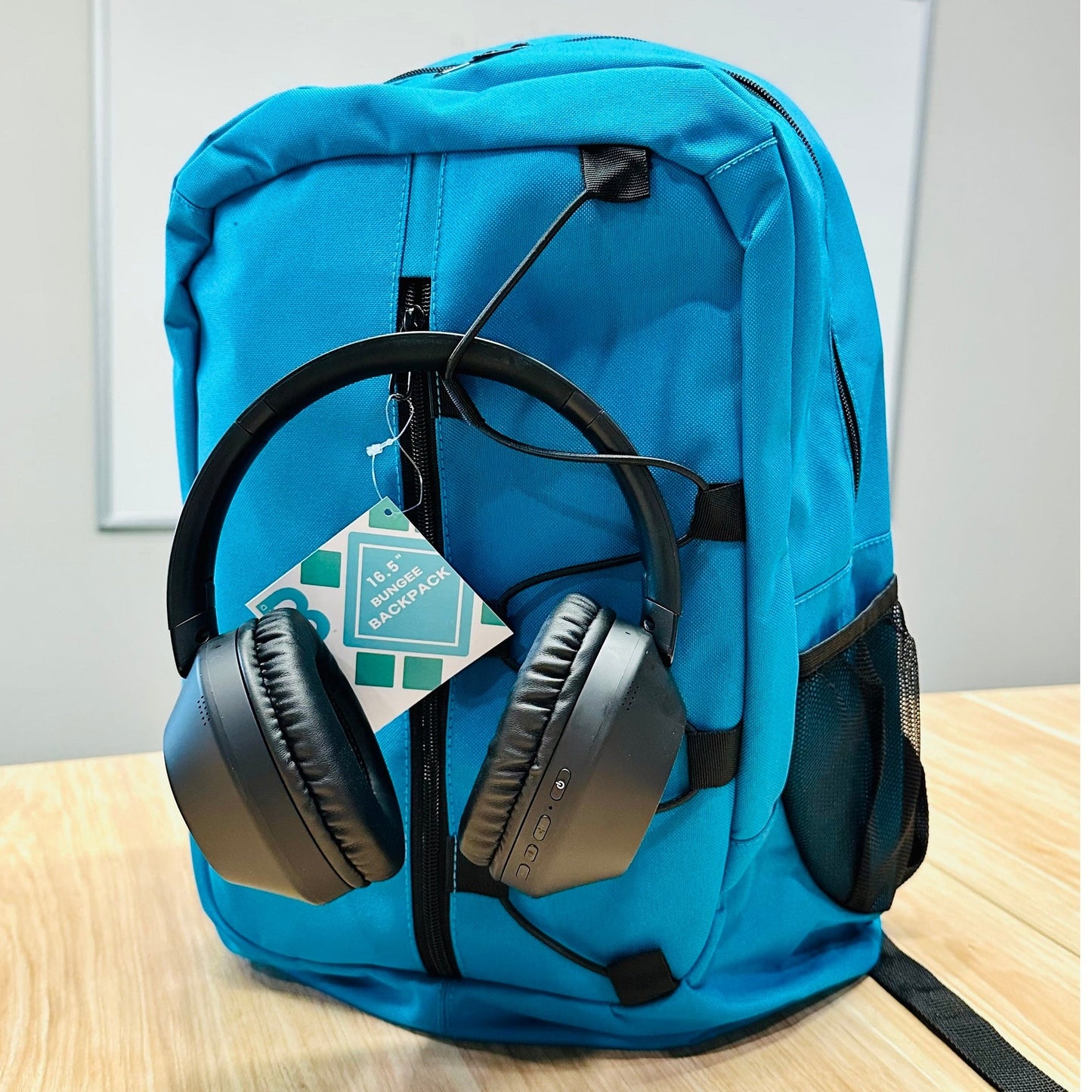 A blue backpack with black headphones and a product tag.