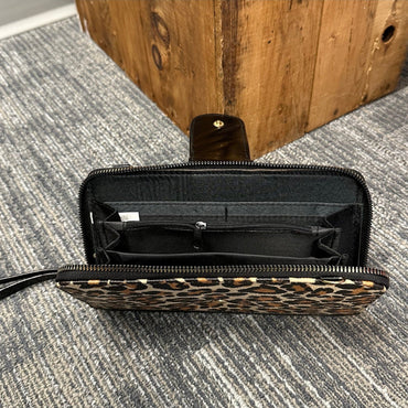 Leopard print wallet with a black interior and wrist strap.