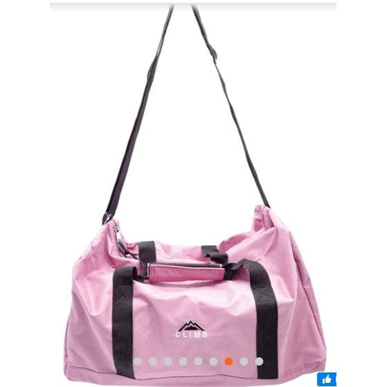 Pink canvas duffel bag with black straps.