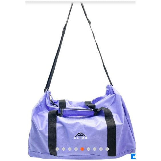 Lavender duffel bag with black handles and shoulder strap.