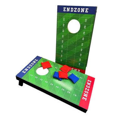 Two cornhole game boards with an American football field design and red and blue bean bags.
