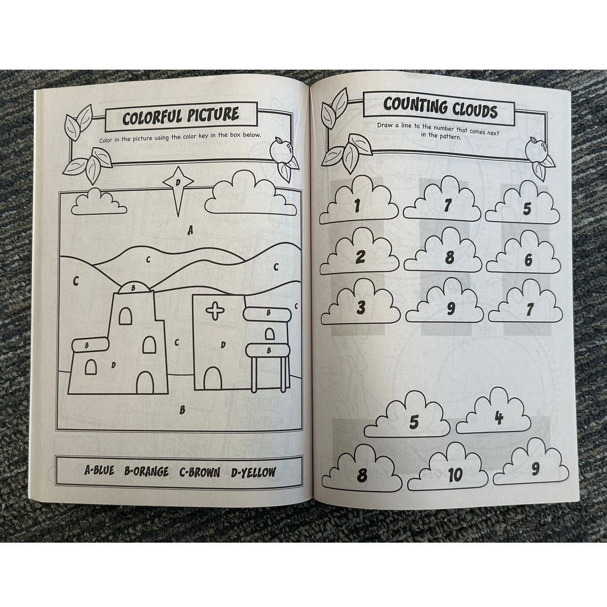 Open coloring/activity book on carpet.