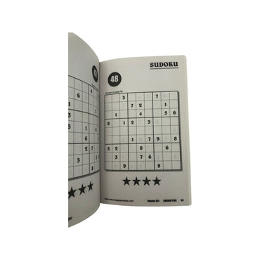 A Sudoku puzzle book opened to two puzzles.