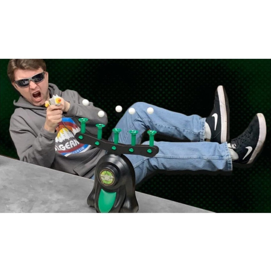 Person firing a toy gun at a target in a home setting.