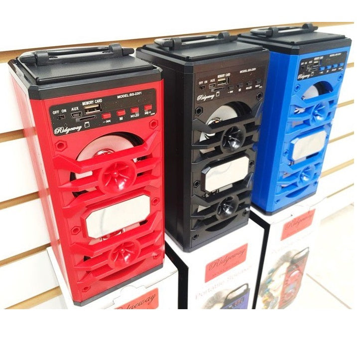 Three Ridgeway speakers in red, black, and blue standing on white boxes.