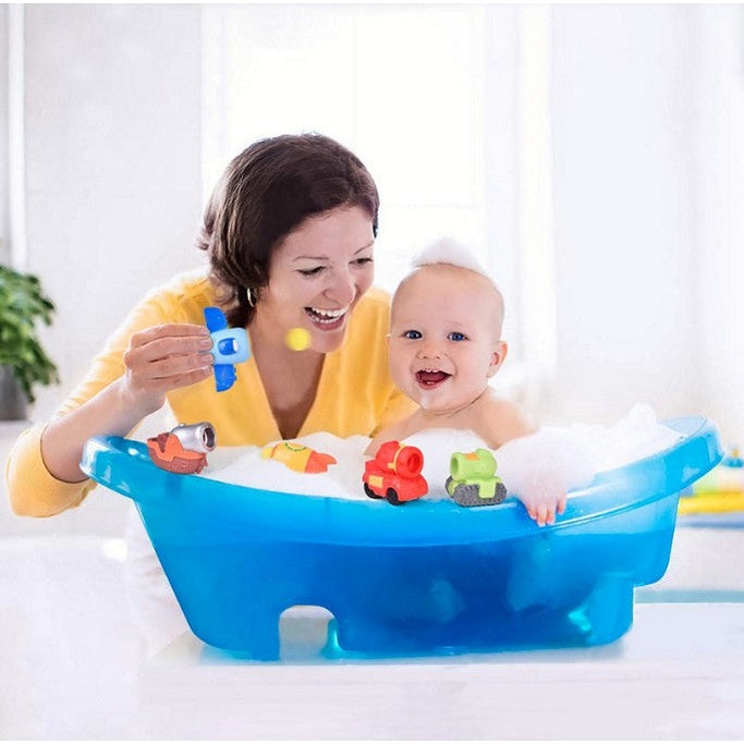 A woman and baby in a blue bathtub filled with bubbles and toys.
