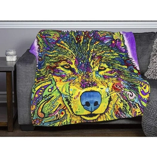 Close-up of a colorful, wolf-themed blanket draped over a gray couch.