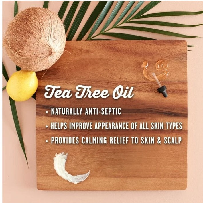 Product shot for Tea Tree Oil on a wooden board with coconut, lemon, palm leaf, oil droplet, and lotion sample.