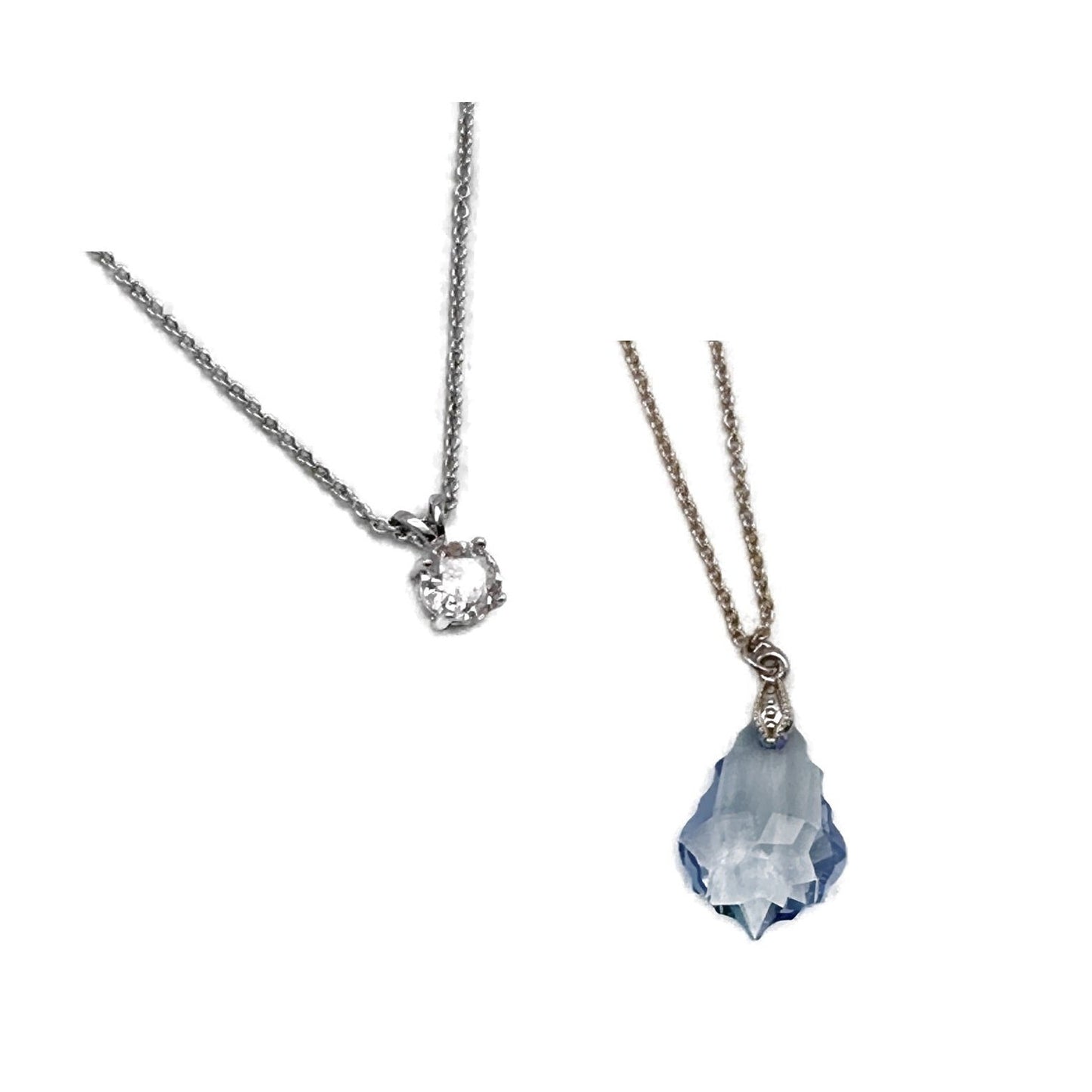 Two necklaces on silver chains. One with a white stone, the other with a blue crystal.
