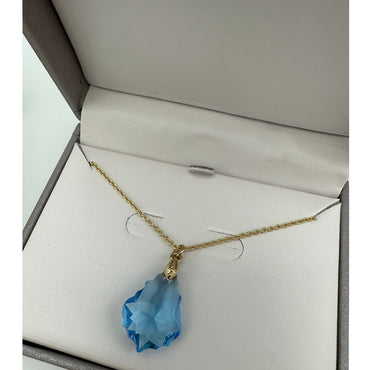 Blue crystal pendant necklace in a gray box.