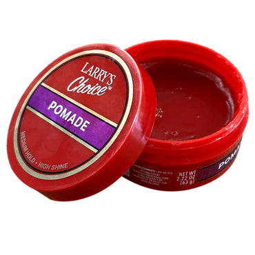 An opened container of red pomade with the lid propped next to it.