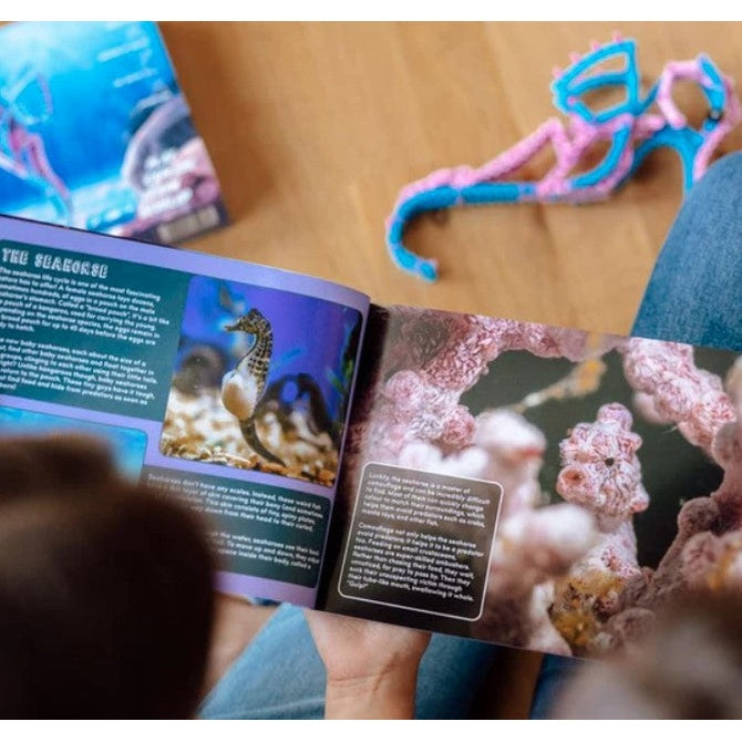Open book about sea creatures, yarn sea creature craft, blue jeans.