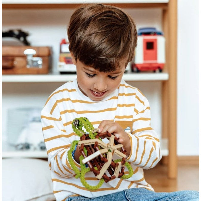 A child in a striped shirt plays with a toy turtle.