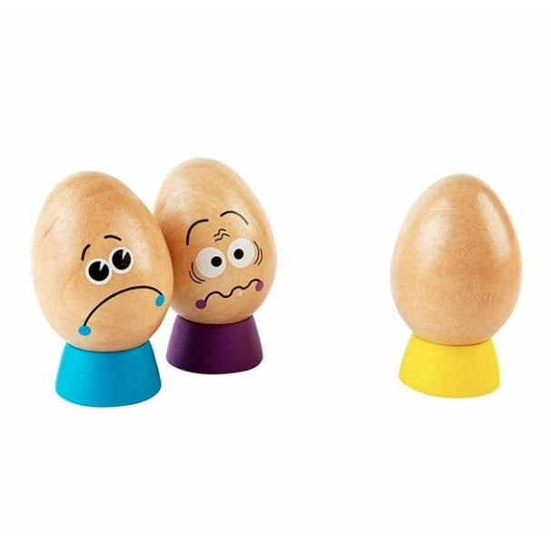 Three wooden eggs with painted faces and colorful bases.