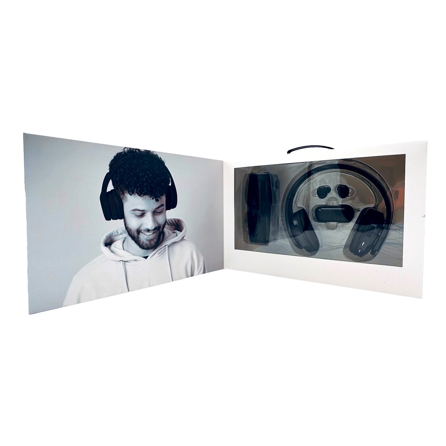 Open product packaging for black headphones with a photo of a smiling man wearing the same headphones.