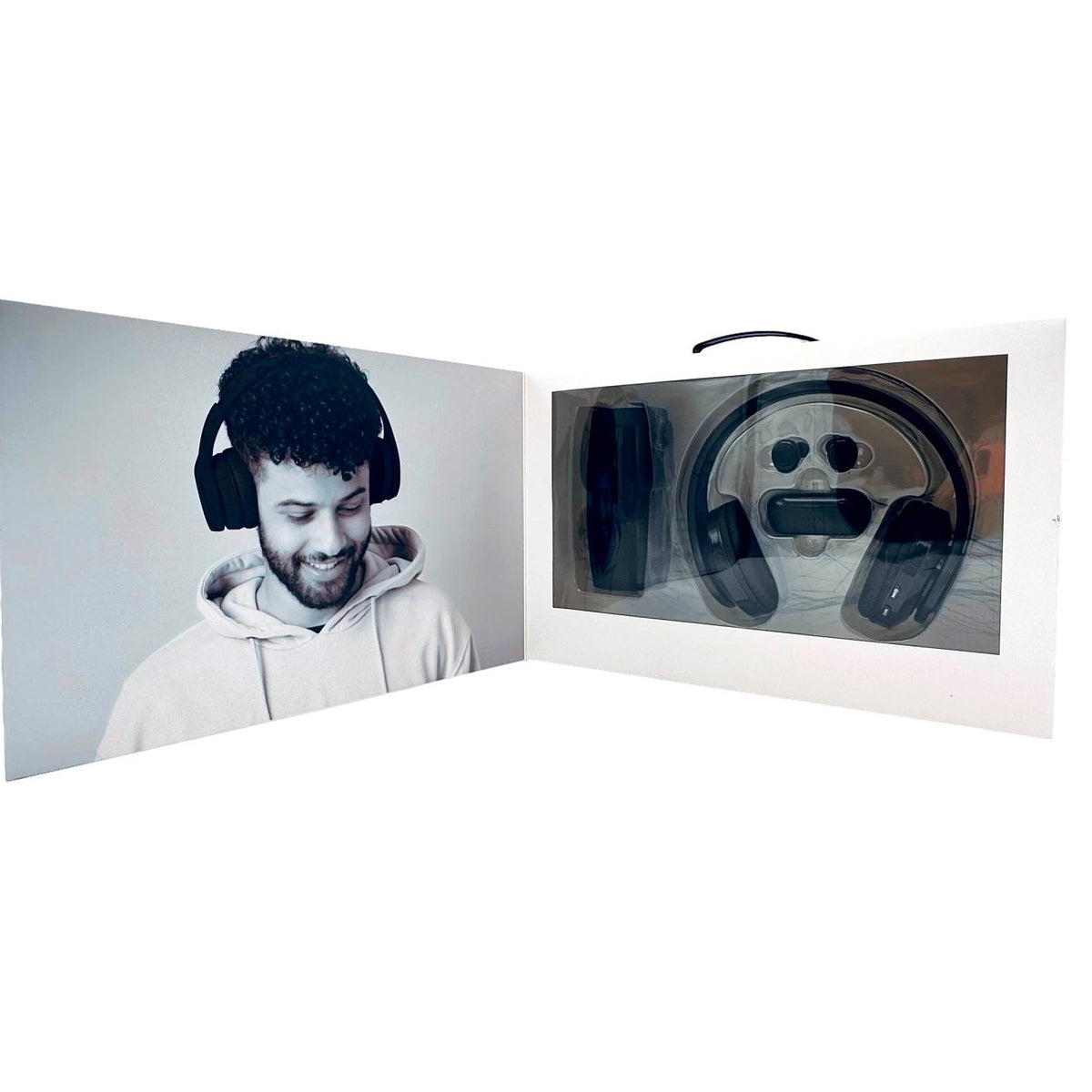 Open product packaging for black headphones with a photo of a smiling man wearing the same headphones.