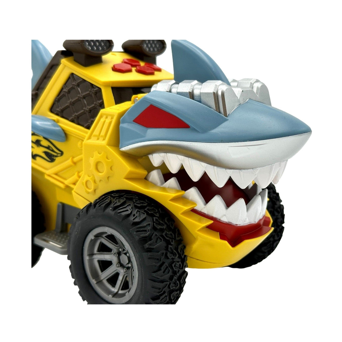 Yellow toy shark truck with oversized tires and gray shark head.