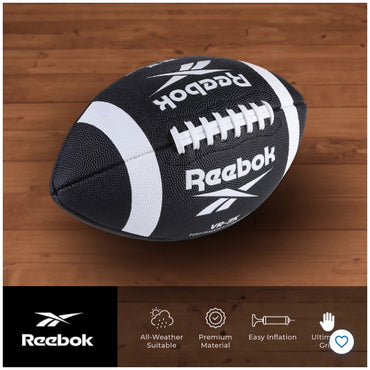 Black and white Reebok football on a wood floor.