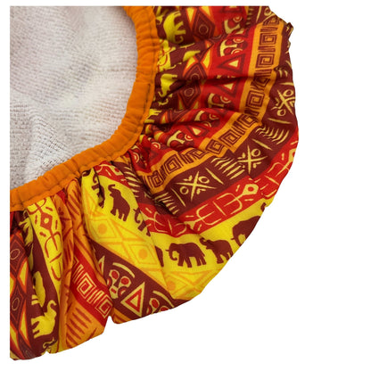 Cloth diaper with orange trim and red, brown, and yellow African print.