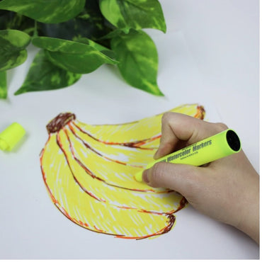 A hand coloring a banana drawing with a yellow marker.
