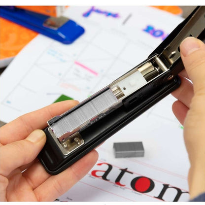 A black stapler held open, loaded with staples.
