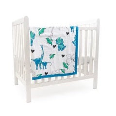 Here are a few descriptive alt tags for the image:

*   White crib with dinosaur-themed blanket.
*   Baby crib with blue and green dinosaur quilt.
*   Nursery decor: white crib and dinosaur baby blanket.