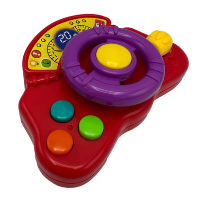 A red plastic toy steering wheel with a purple wheel, yellow center button, and a speedometer graphic.