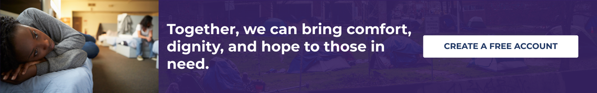 A dark blue promotional banner with a photograph of a person sleeping on a bed in a softly lit room. Large white text reads, 'Together, we can bring comfort, dignity, and hope to those in need,' with a white button on the right that says 'CREATE A FREE ACCOUNT.