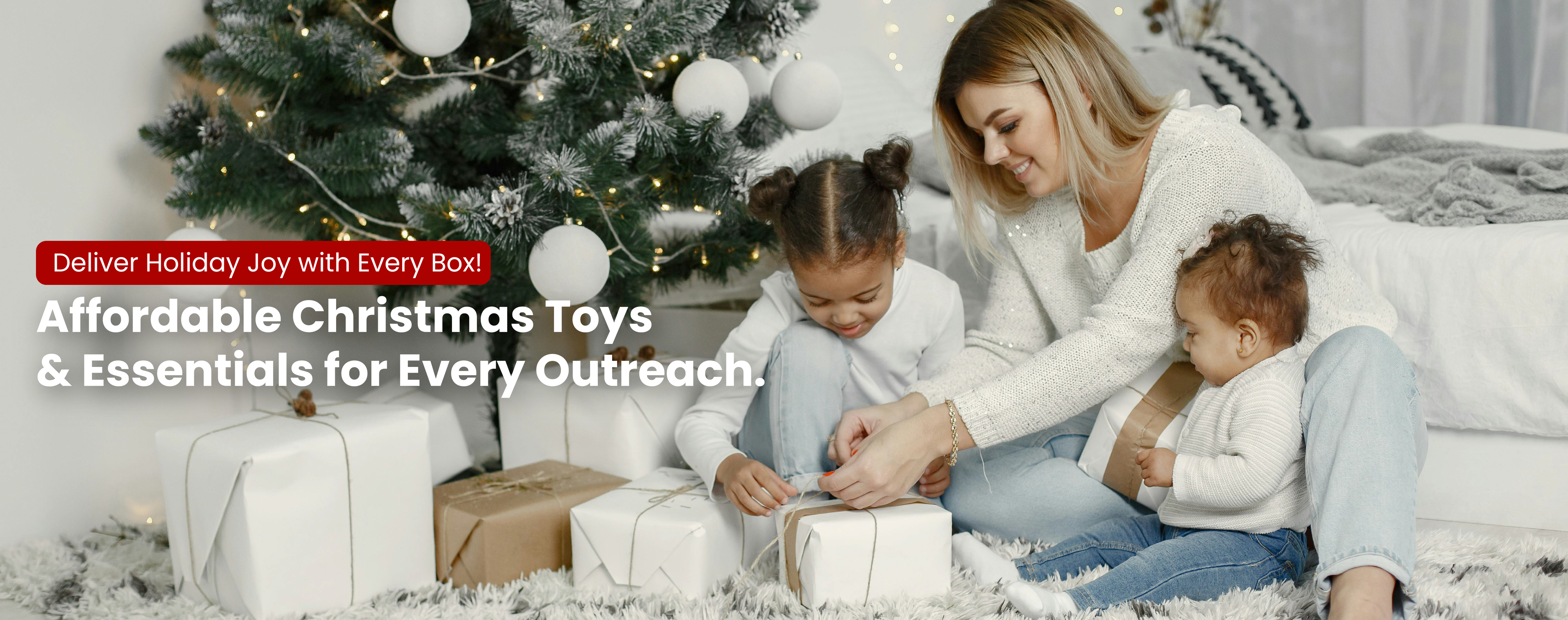 Woman and two children opening a gift in front of a decorated Christmas tree.