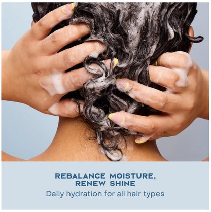 Person washing hair with text 'Rebalance moisture, renew shine' on a light blue background
