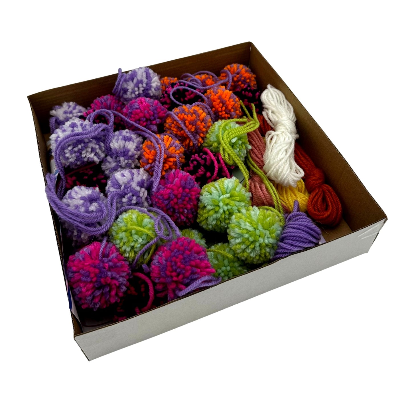 A box filled with colorful yarn pom-poms and spools of yarn.