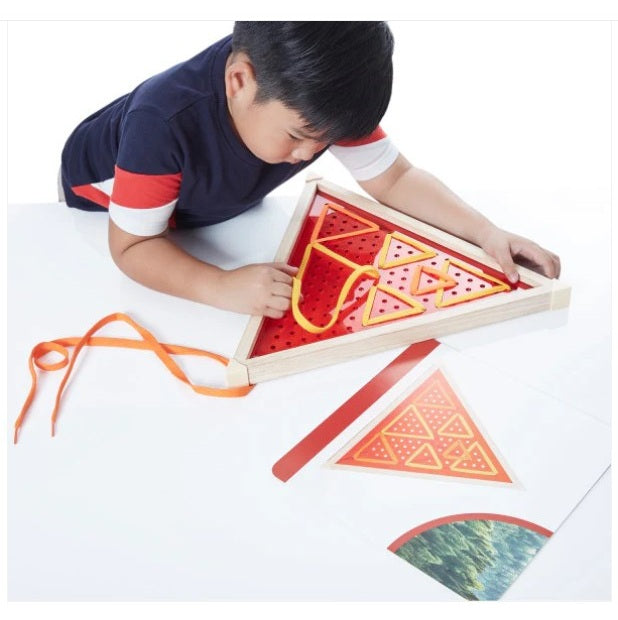 Child playing with a geometric shape puzzle on a white surface