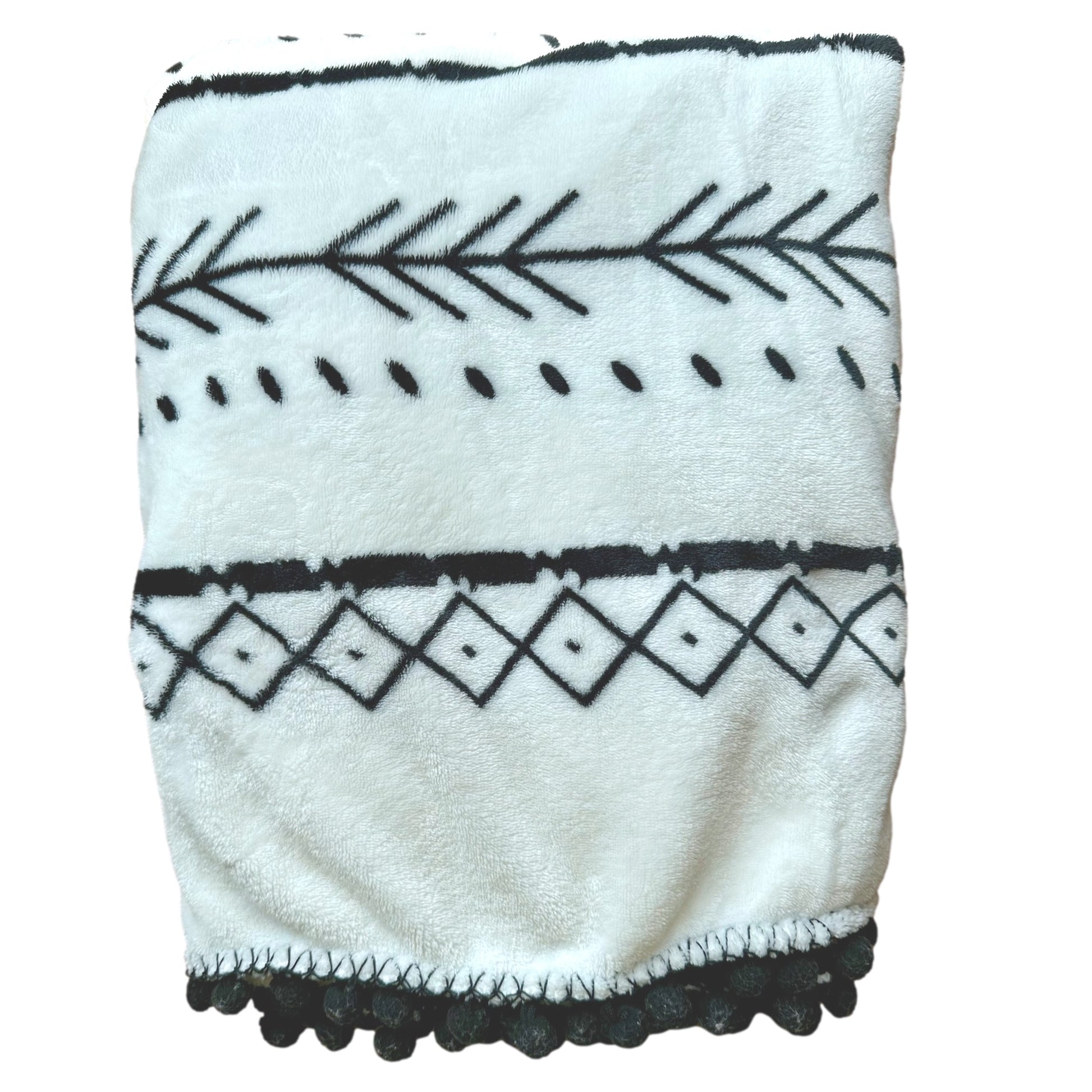 White blanket with black geometric patterns and pom-pom fringe.
